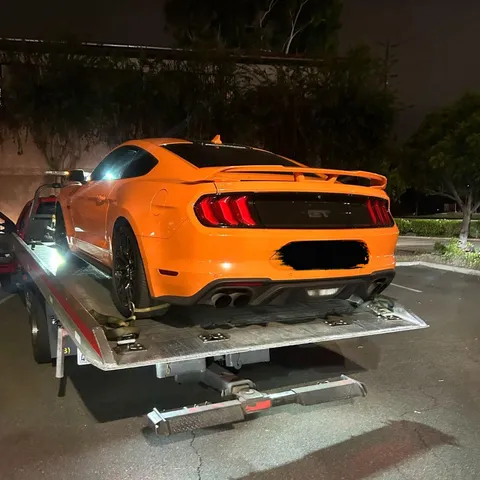 Tow truck loading stalled vehicle at night in Brea California