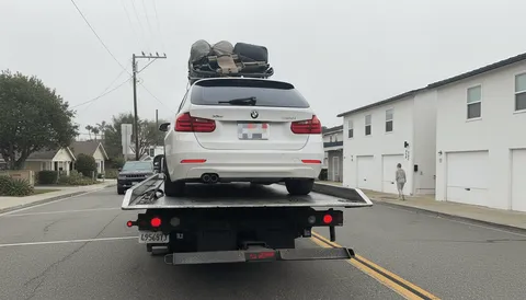 White car secured on flatbed tow truck in Riverside County California