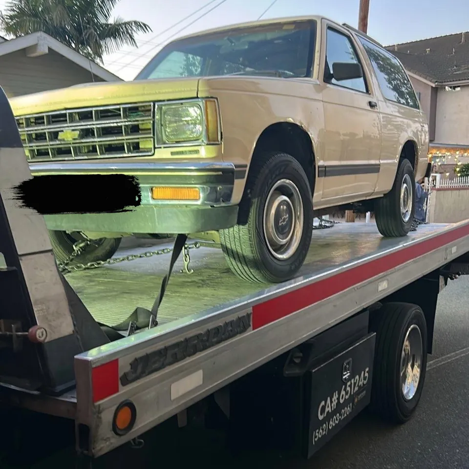 Flatbed tow truck loading broken down SUV in Buena Park California daytime