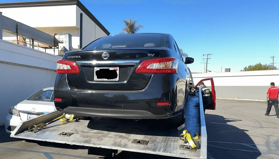 Black car on flatbed tow truck during daytime in Pico Rivera California