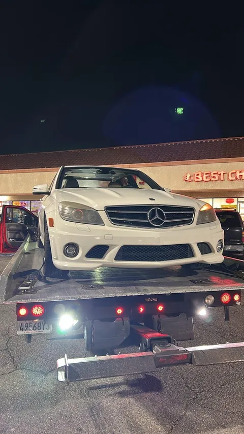 White car on flatbed tow truck for emergency towing in Cerritos California