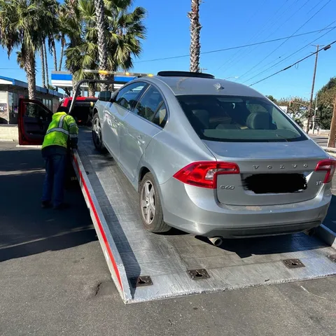 Flatbed tow truck lowering stalled vehicle in Bellflower CA