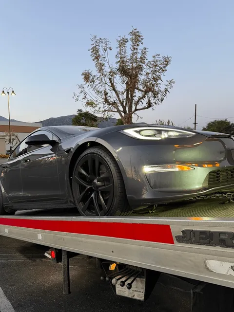 Flatbed tow truck loading a model3 Tesla in La Palma, CA offering unparalleled towing and roadside assistance to stranded drivers in the Los Angeles area