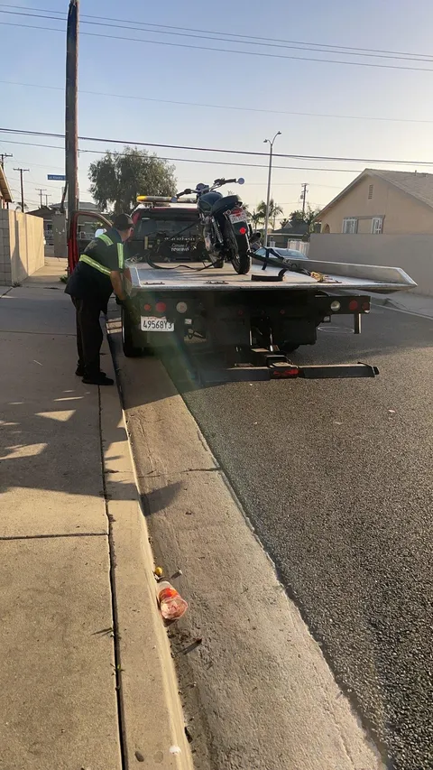 Towing service safely transporting a motorcycle after roadside breakdown in Cypress, California.