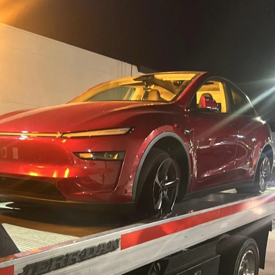 Flatbed tow truck assisting broken down car at night in Brea California