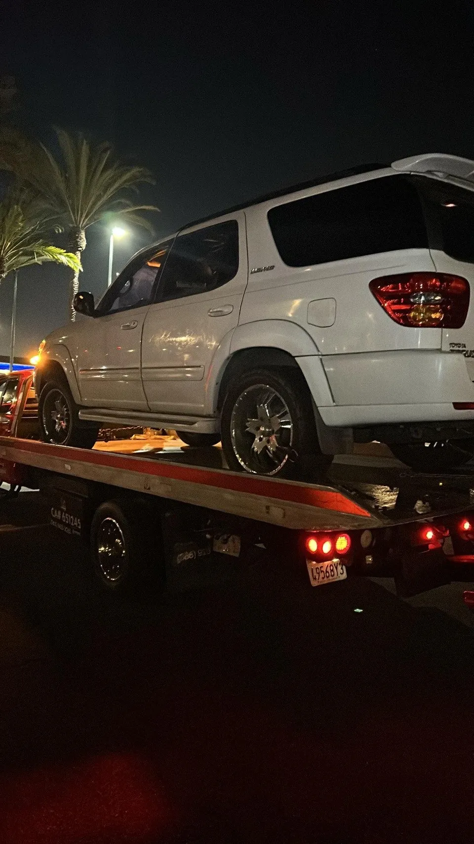 White van on flatbed tow truck at night in Fullerton California