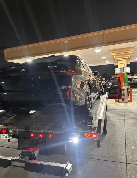 Gas station flatbed towing service by a red Carsaad Towing truck for a BMW 550 in La Mirada CA on July 19, 2026