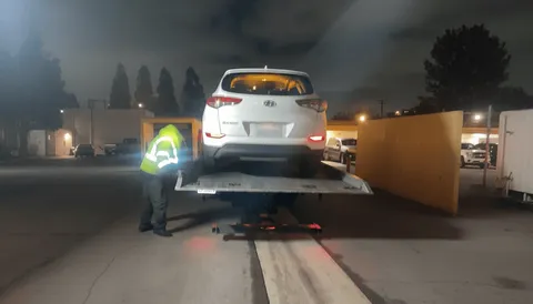 White car towing service at night in Lakewood California