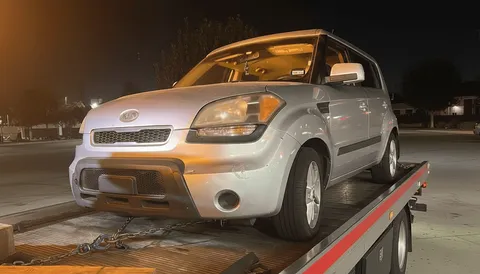 White car on tow truck at night parked in Rossmoor California