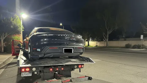 Black car towed and parked at night in Santa Ana California