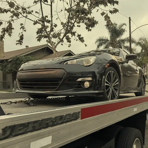 Tow operator loading a stranded vehicle onto a truck on an Anaheim roadside.