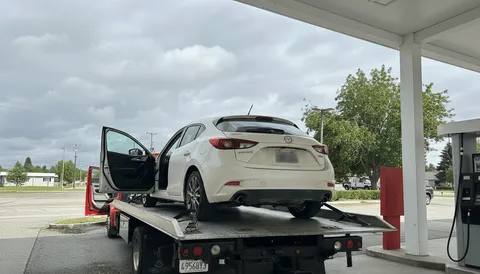 White car on tow truck during daytime in Los Alamitos California