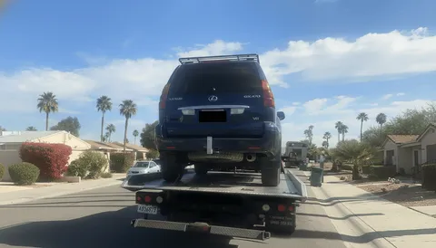 Tow truck assisting stalled vehicle on roadside in Bell Gardens CA during daytime
