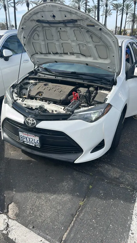 Tow truck providing roadside assistance with jump start for a white car in East Whittier, California. Fast and safe service.