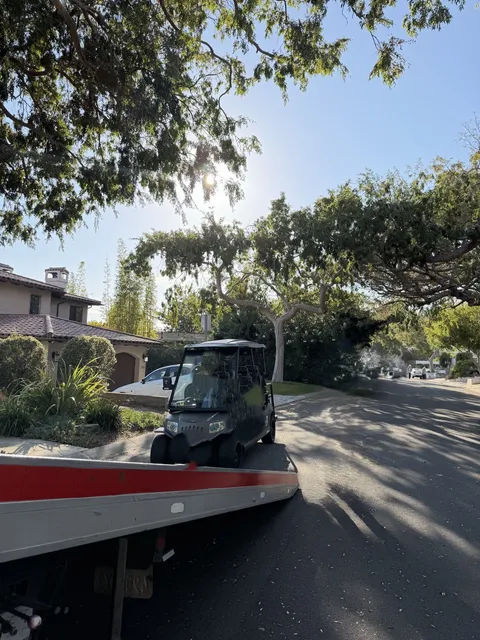 Red truck towing a broken down golf cart in Seal Beach, CA