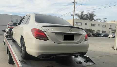 White car being loaded onto flatbed tow truck in West Whittier California